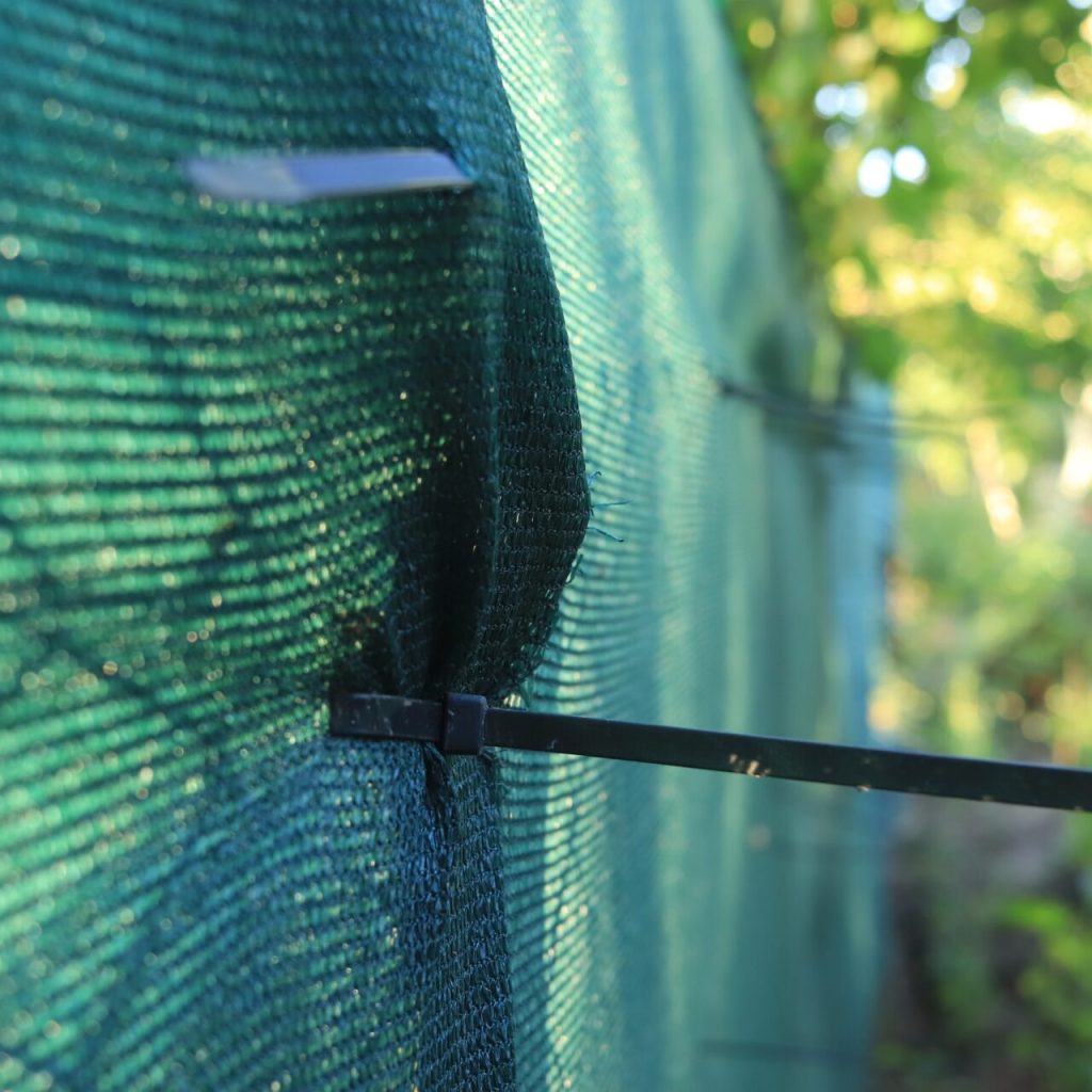 Green fencing netting installed on a construction site fence