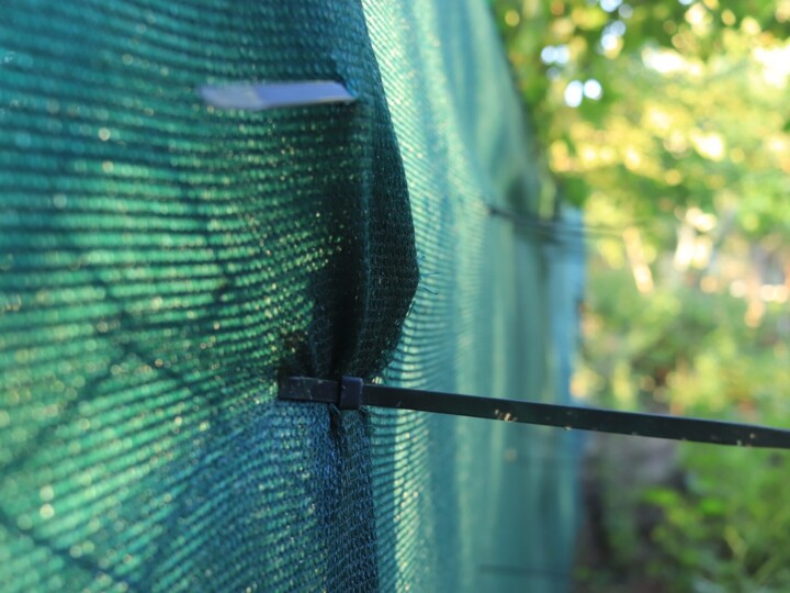 Green fencing netting installed on a construction site fence