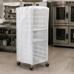 Housse de protection industrielle pour chariot en milieu alimentaire, recouvrant un rack mobile dans une cuisine commerciale afin de protéger les équipements contre la poussière et les contaminants