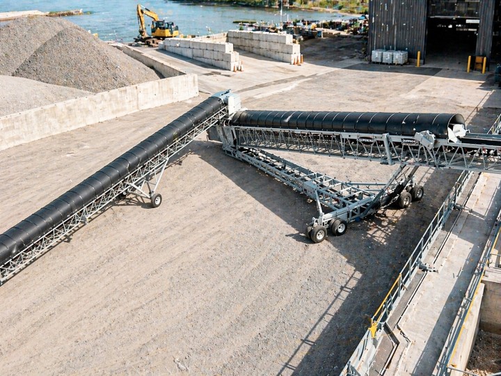 Housses de protection pour convoyeurs de vrac en vinyle noir installées sur des convoyeurs industriels, utilisées pour contenir les matériaux et protéger les opérations en environnement portuaire