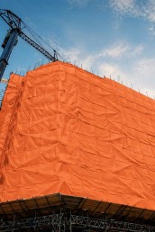 Toile isolante industrielle installée sur un bâtiment en construction, utilisée pour protéger le chantier et maintenir la température lors de travaux par temps froid