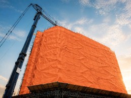 Industrial insulated tarp installed on a building under construction, used to protect the work site and maintain the temperature during work in cold weather.
