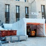 Film thermorétractable (shrink wrap) installé sur un échafaudage afin de créer un espace de confinement étanche pour des travaux de construction.