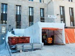 Heat-shrink film installed on scaffolding to create a watertight containment area for construction work.