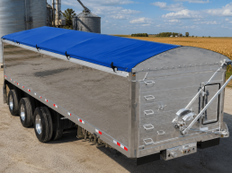 Blue grain tarp mounted on an aluminum grain trailer for the safe transport of grain and bulk products.